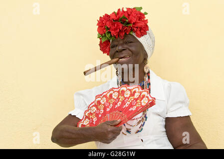 Ein alltäglicher Anblick in der alten Stadt von Havanna in Kuba - wird normalerweise eine ältere Dame in Tracht, eine Zigarre rauchend kleiden. Stockfoto