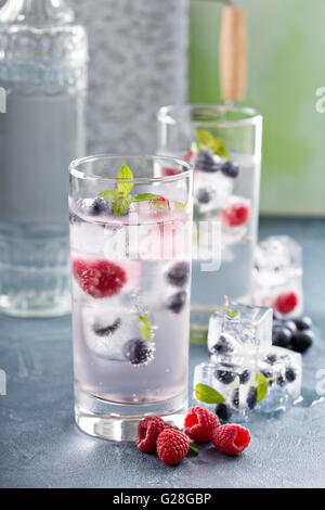 Mineralwasser mit Beeren und Kräuter-Eis Stockfoto