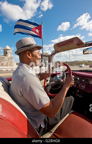 Eine kubanische Taxifahrer fahren his1955 Pontiac Star Chief Cabrio in Havanna, Kuba. Stockfoto