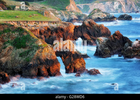 Abendrot entlang Kaliforniens zerklüfteten Big Sur Küste mit den historischen Rocky Creek Bridge am Highway 1. Stockfoto