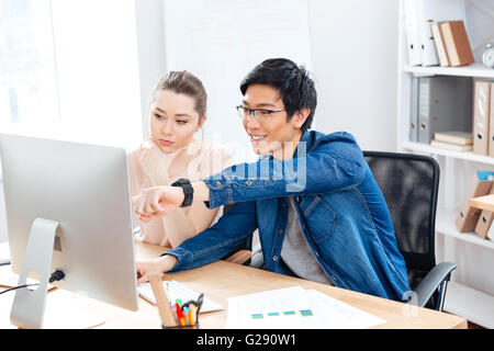 Zwei junge Unternehmer sitzen und gemeinsam im Büro Stockfoto