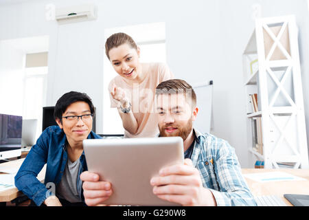 Drei konzentriert junge Geschäftsleute mit Tablet zusammen zu arbeiten Stockfoto
