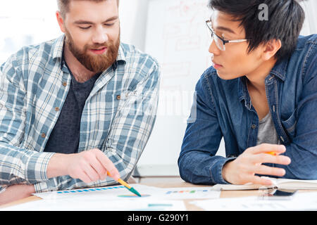 Zwei junge Unternehmer diskutieren Businessplan im Büro Stockfoto