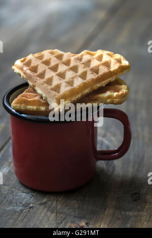 herzförmige Waffeln und Kaffee am Tisch in der Nähe von Stockfoto