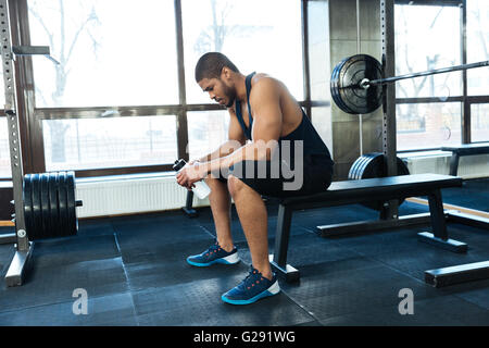 Afro american Fitness Mann ruht auf der Bank in der Turnhalle Stockfoto