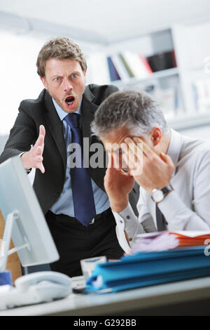 Ältere Manager schreien an seine Büroangestellte Stockfoto