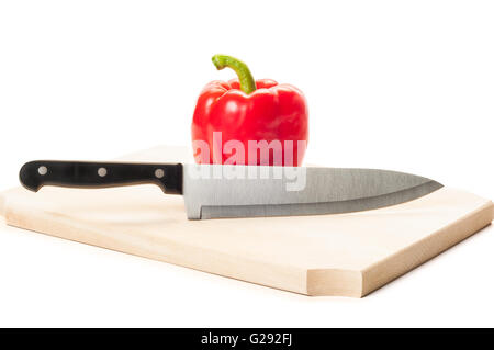 Stahl-Messer und Fett Paprika auf einem Holzbrett isoliert auf weißem Hintergrund. Stockfoto