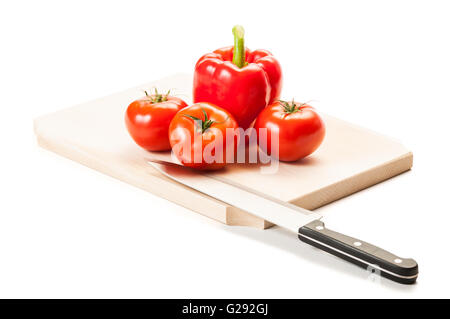 Drei perfekte rote Tomaten, eine dicke rote Paprika, Stahl Messer und Holzbrett, alles isoliert auf weißem Hintergrund. Stockfoto