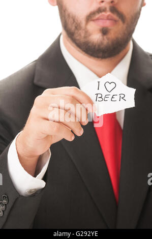 Ich liebe Bier Konzept mit ein Mann trägt einen schwarzen Anzug und roter Krawatte und hält ein Stück Papier mit dem Text ich liebe Bier auf i Stockfoto