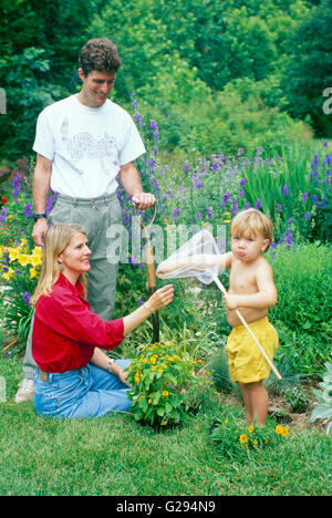 Familie und junge Junge im Garten mit Schmetterlingsnetz macht ein Gesicht an der Kamera, Missouri, USA Stockfoto