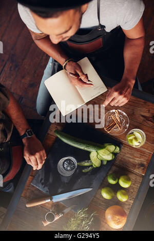 Zwei Barkeeper experimentieren mit Cocktails erstellen, diskutieren über neue Ideen und Notizen. Draufsicht der Barmer mit Stockfoto