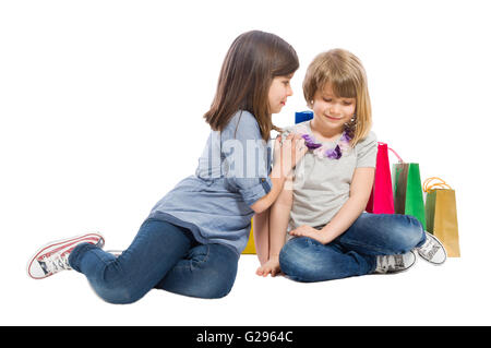 Junge shopping Schwestern spielen auf weißer Hintergrund Stockfoto