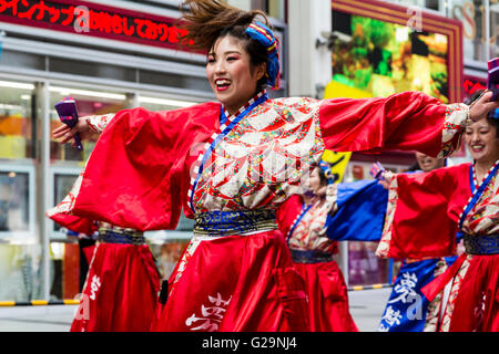 Japan, Kumamoto. Hinokuni Yosakoi Dance Festival. In der Nähe von Japanischen junge Frau Tänzer, Teil einer Mannschaft, die Arme ausgestreckt, Tanz in der Mall. Stockfoto