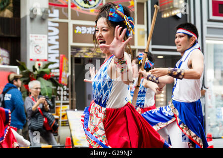 Japan, Kumamoto. Hinokuni Yosakoi Dance Festival. In der Nähe von Japanischen junge Frau Tänzer, Teil einer Mannschaft, die Arme ausgestreckt, Tanz in der Mall. Stockfoto