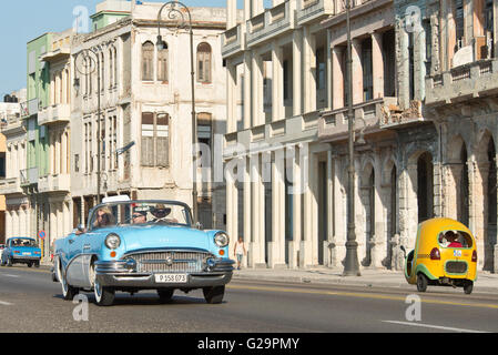 Eine komprimierte perspektivische Ansicht ein 1955 Buick Special Cabrio und ein Coco-Taxi Fahrt entlang des Malecón in Havanna, Kuba. Stockfoto