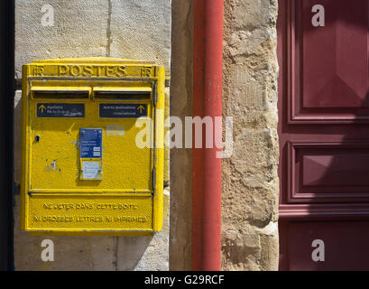 Französische gelbe Metallbriefkästen auf Steinwand in einer Straße von Aquitanien. Frankreich. Stockfoto