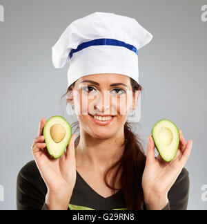 Frau Koch hält eine Avocado Frucht und lächelnd Stockfoto