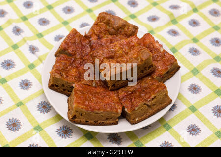 Fleischpastete in große Stücke schneiden und auf einen Teller legen Stockfoto