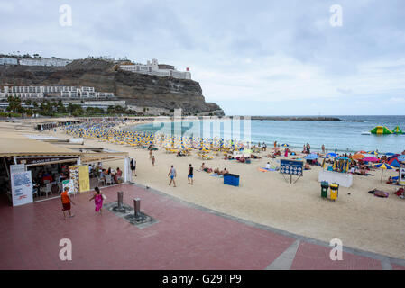 Touristen packen Amadores Strand im Süden von Gran Canaria, trotz bewölktem Himmel Stockfoto