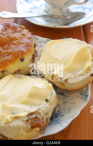 Gebutterte Obst Scones und Nachmittagstee auf China Platten Stockfoto