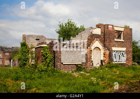 Einsame, unsichere, überwucherten 1803 Red brick Bauernhof, Gebäude, in armen Reparatur eine gefährliche Struktur im Burscough, Lancashire, Großbritannien Stockfoto