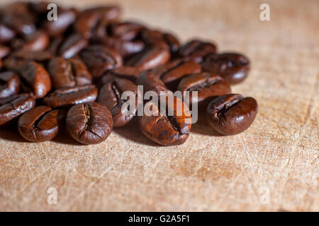 Nahaufnahme Bild von Kaffeebohnen auf einem hellen farbigen Holzbrett Stockfoto