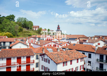 Blick auf die Dächer von typischen Gebäuden und Glockenturm der St. Vicent Kirche von Ciboure im Baskenland. Aquitaine, Frankreich. Stockfoto