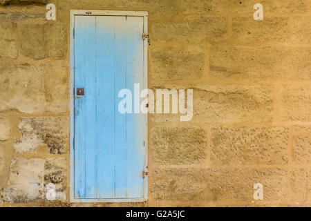 Verwitterte blau Holztür mit einem metallischen rostigen Schloss mit Farbe gesäumt und Peeling texturiert. Stockfoto