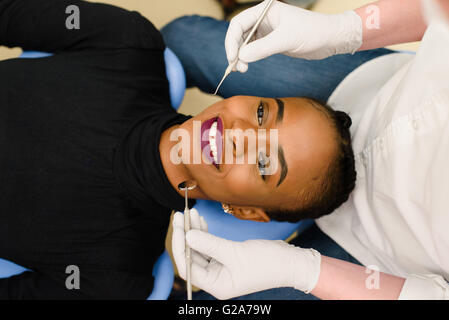 Young African-American ethnischen schwarze Frau beim Zahnarzt in weißen Latexhandschuhe Prüfbedingung ihrer Zähne Lächeln Stockfoto