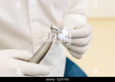 Hand des Zahnarztes in weißem Latex-Handschuhe halten dental Bohren Maschine mit Turbine, Nahaufnahme Stockfoto