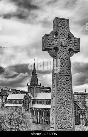 Ein monochromatisches Bild ein keltisches Kreuz Grabstein befindet sich auf dem Friedhof der Nekropole in Glasgow, die mit Blick auf die Kathedrale. Stockfoto