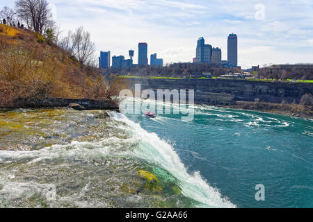 Niagara Falls, Fähre in Niagara River und Wolkenkratzer von der kanadischen Seite. Ein Blick auf die American Falls Stockfoto