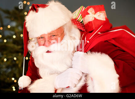 Porträt von Santa Claus Sack über die Schulter zu tragen Stockfoto