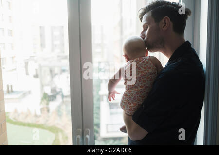 Vater Blick durch Fenster mit Tochter (2-5 Monate) Stockfoto