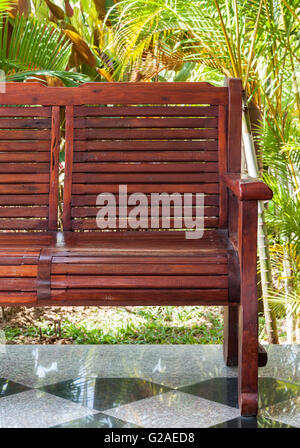 Roten Holzbank auf der Terrasse in der Nähe von dem kleinen Garten des Landhaus. Stockfoto