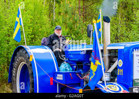 Emmaboda, Schweden - 14. Mai 2016: Wald und Traktor (Skog Och Traktor) fair. Essen eine Banane beim Anlassen des Motors der Fahrer Stockfoto