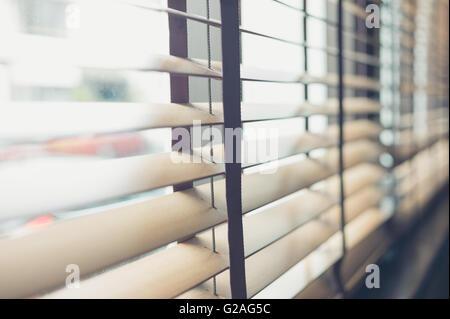 Sonnenlicht, das durch Jalousien am Fenster Stockfoto