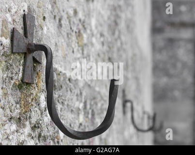 Eisen Haken an der Wand mit Dekoration in Form eines Kreuzes. Defokussierten unscharfen Hintergrund. Stockfoto