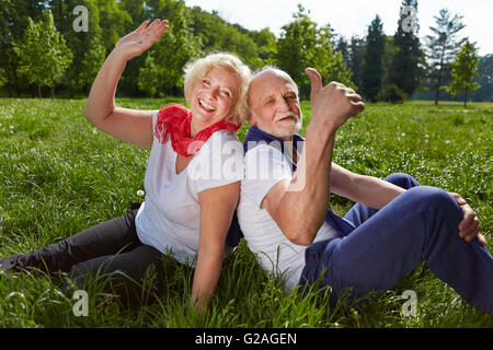 Lächelnd senior Brautpaar in Sommerferien winken Hände und Daumen hochhalten Stockfoto