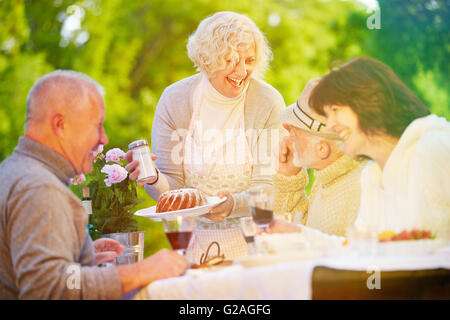 Freunde und ältere Leute feiert Geburtstag mit Kuchen im Garten-party Stockfoto