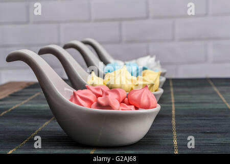 Regenbogen Süßigkeiten auf Tisch und Ziegel Hintergrund Stockfoto