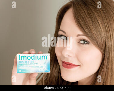 Porträt einer Frau mit einer Packung Imodium Bauch aufgeregt Tabletten Stockfoto