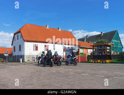 Ventspils, Lettland - 8. Mai 2016: Altes Haus und Biker am Ufer des Flusses Venta in Ventspils in Lettland. Stockfoto