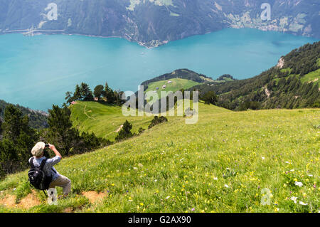 Wanderer auf einem Trail hoch über dem Vierwaldstättersee, ein Bild von der See und seine Umgebung. Kanton Uri, Zentralschweiz. Stockfoto