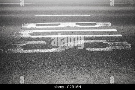 Bus-Beschriftung auf dunklen urban Asphaltstraße Stockfoto