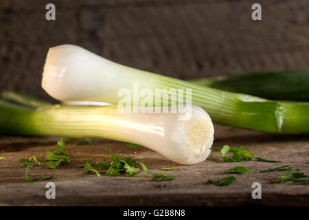 Frühlingszwiebeln auch bekannt als Salat Zwiebeln, Frühlingszwiebeln oder Schalotten auf Holz Hintergrund Stockfoto