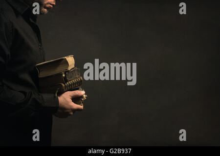 Mann, der alte Bücher in seinen Händen hält Stockfoto