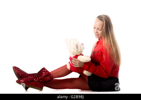 Porträt von glücklich schön lässig Teenager-Mädchen in rote Lederjacke spielt mit Teddybär, lächelnd, Studio, weißer Hintergrund Stockfoto