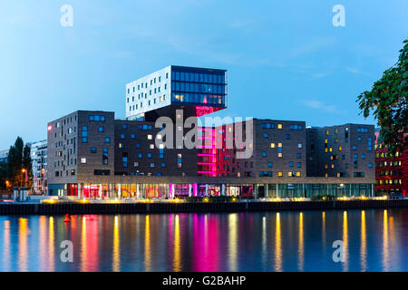 Nhow Hotel eröffnet im Jahr 2010 als Musik und Lifestyle Hotel an der Spree in Berlin. Nhow Hotel beleuchtet in der Nacht, über Spree Fluss gesehen. Stockfoto