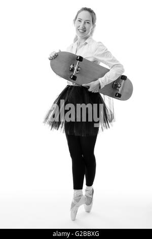 Voller Länge Studioaufnahme von einer Ballerina Geschäft Modell de Pointe eine Skateboard in der einen Hand festhalten.  isoliert auf weiss Stockfoto